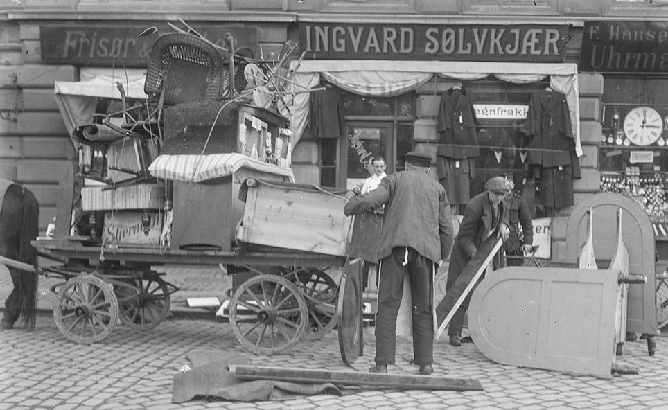 Fladvogn med flyttelæs. Registreringen af billedet fortæller, at der flyttes for husvilde. Foto: Lars Peter Elfelt, 1916, Det kgl. Biblioteks billedsamling.