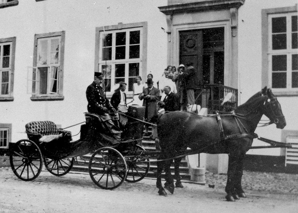 Kristian Kusk holder ved hovedtrappen på Gunderslevholm med vis-a-vis "den flade" og tospand. Foto: Næstved Museum, ukendt fotograf.