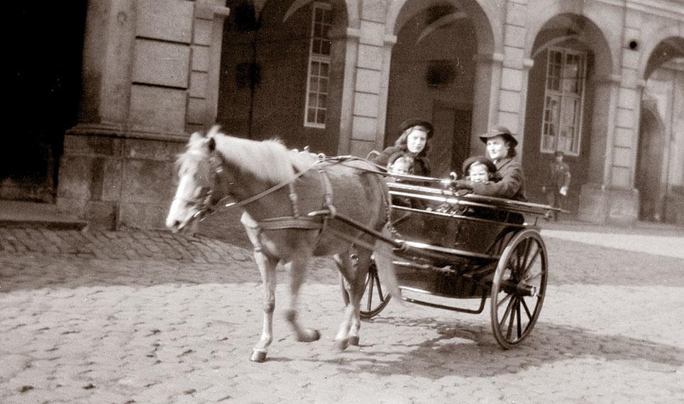 Prinsesserne Benedikte (f. 1944) og Anne-Marie (f. 1946) sammen med deres barnepiger Mary Vorth tv. og Agnete Ohrt i dronning Alexandrines jumbe på Christiansborg Ridebane. Ca. 1949. Foto: Familien Clausen.