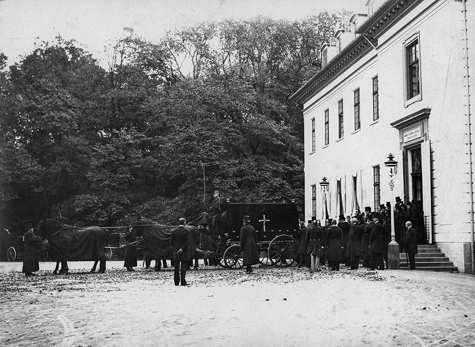 Ved dronning Louises bisættelse i 1898 blev dronningens båre kørt med rustvogn fra Bernstorff Slot. Her var der også tale om en fourgon, der var dækket med mørkt klæde. Hestene bar også sorte skabarakker. Foto: Det kgl. Biblioteks billedsamling.